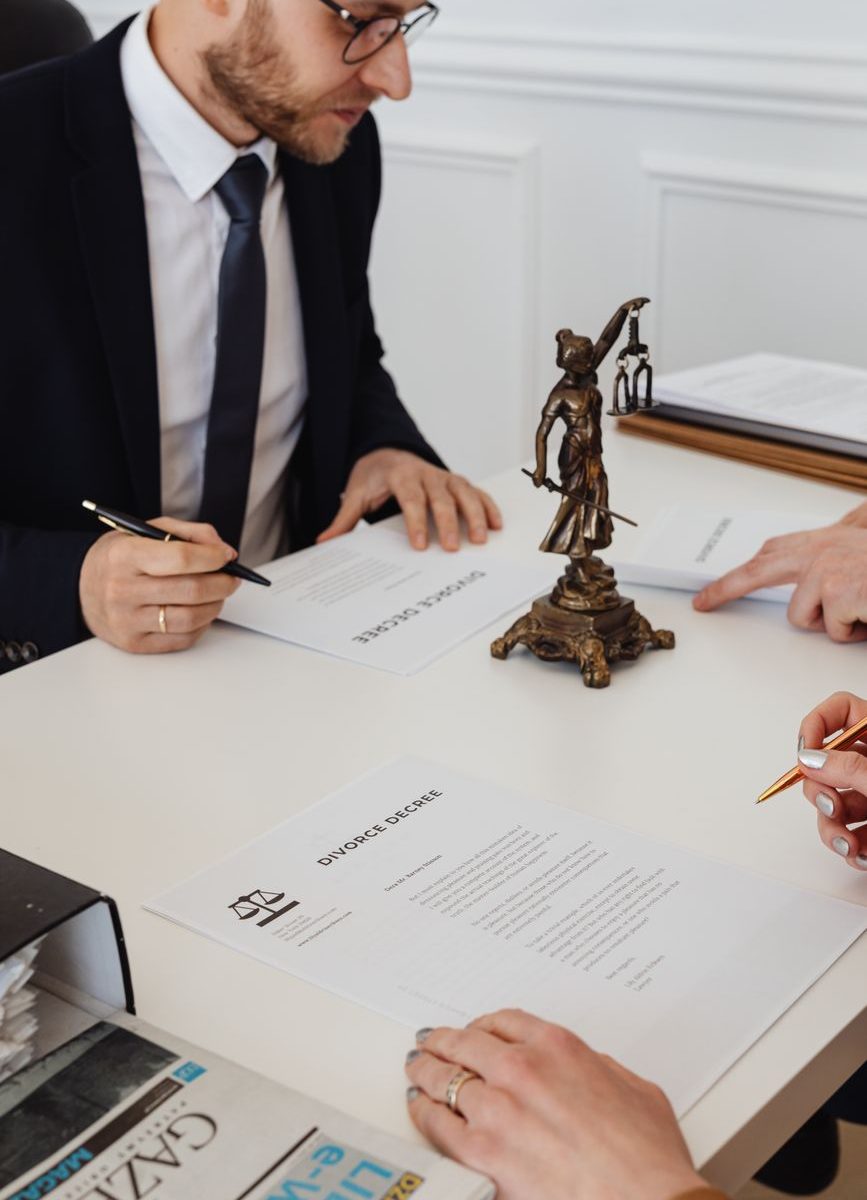 Lawyers reviewing and signing documents in a formal office setting.